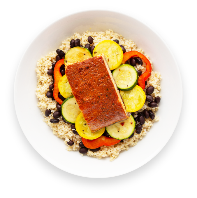 Smoked salmon over rice and baked vegetables with lime and sauce