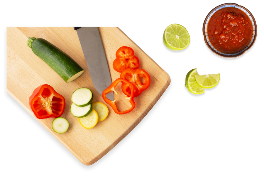 Chopped vegetables on cutting board with knife and sauce