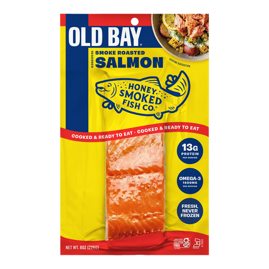 A package of Old Bay Smoke Roasted Salmon from Honey Smoked Fish Co., featuring a bright yellow and blue bag with a clear window showing the smoked salmon inside.